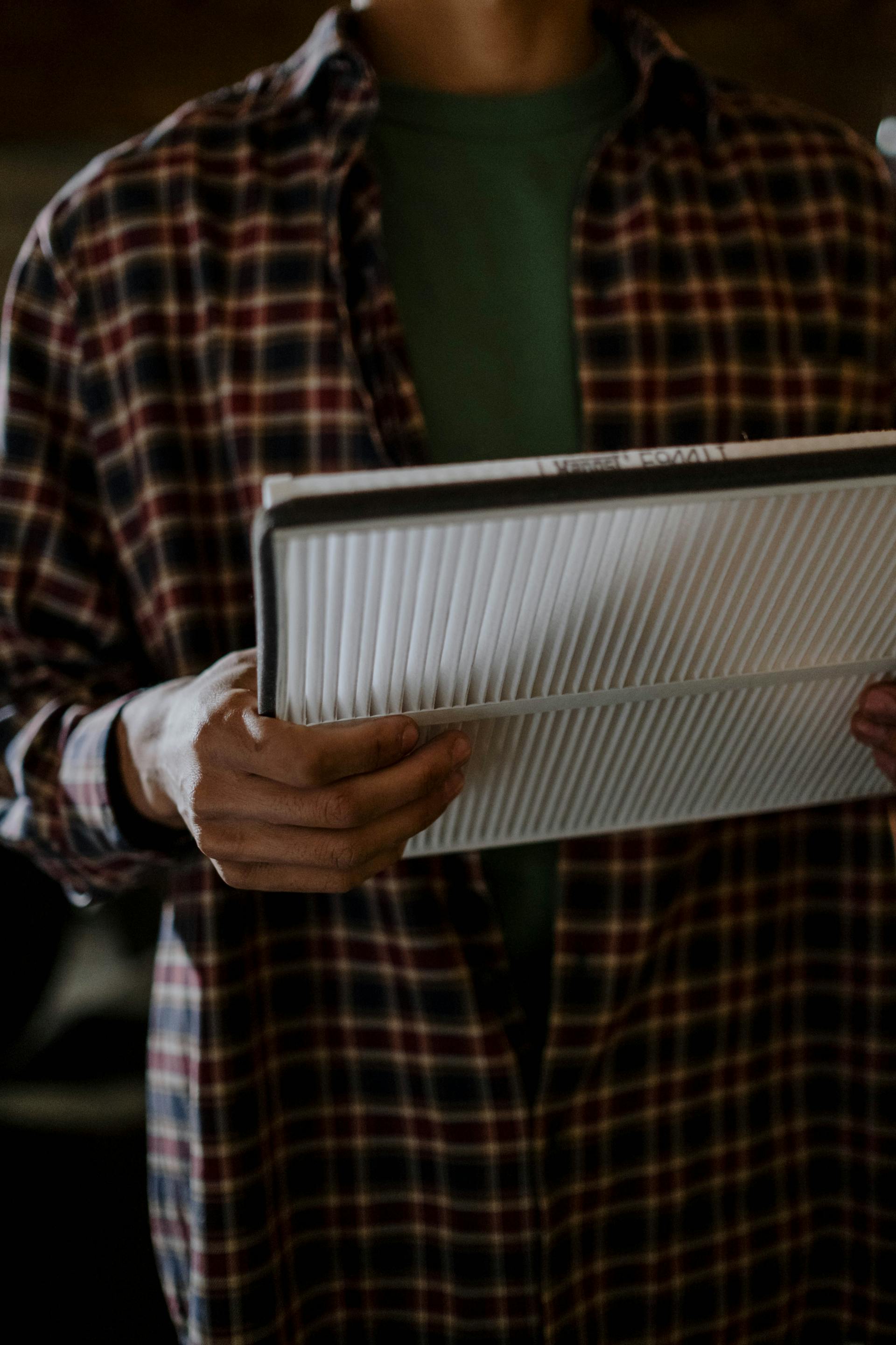 Mechanic holding a car air filter - auto consumables and accessories sourcing